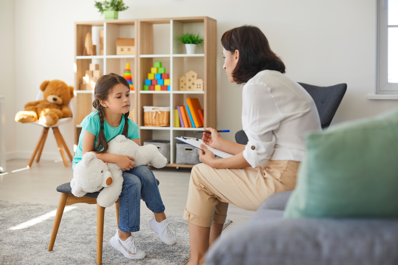 Little Girl Sharing Her Concerns with Supportive Child Psychologist during Therapy Session in